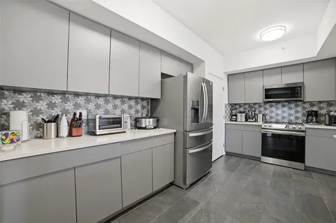 a kitchen with a refrigerator sink and white cabinets