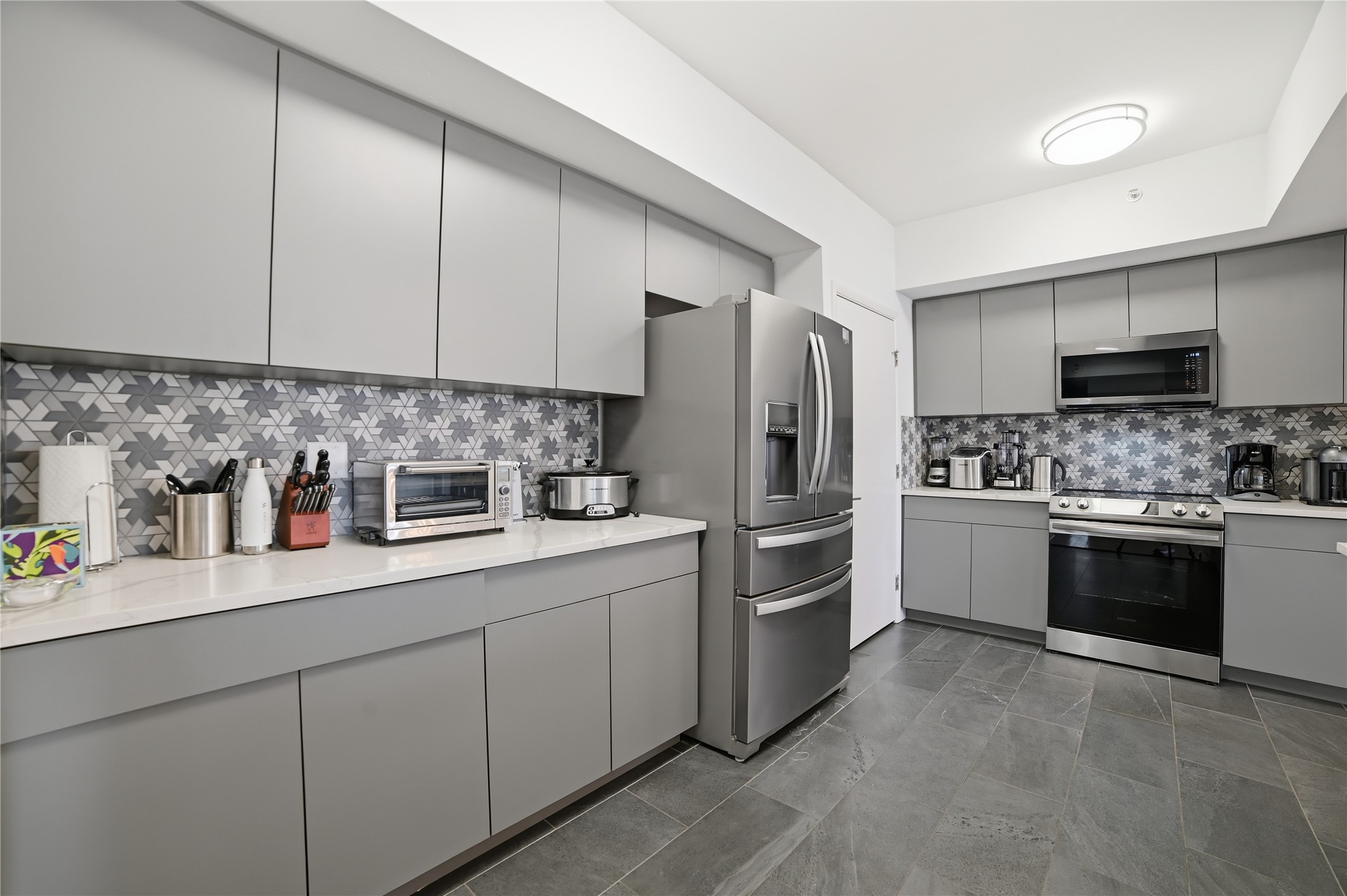 54 Rainey Street, Unit 1018 Austin, TX 78701 - Photo 9 of 32 a kitchen with a refrigerator sink and white cabinets