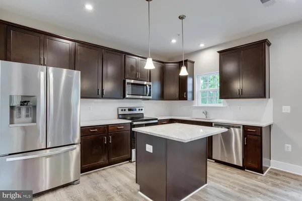 a kitchen with stainless steel appliances granite countertop a sink a stove and refrigerator