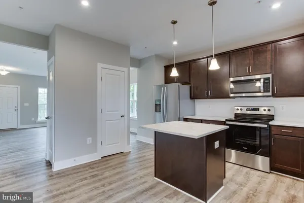 a kitchen with stainless steel appliances granite countertop a sink a refrigerator and a stove