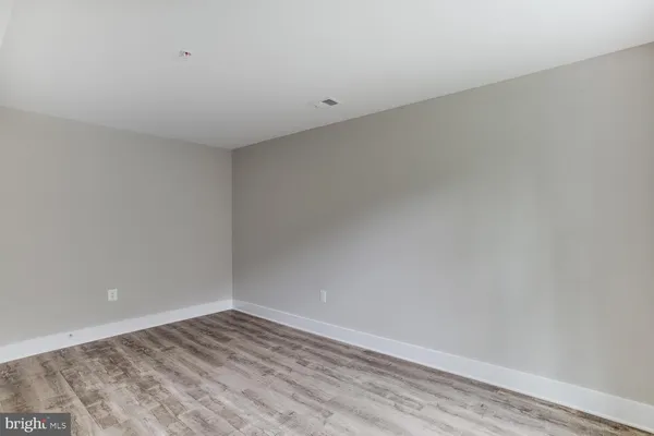 an empty room with wooden floor and closet area