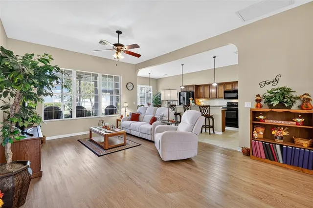 a living room with furniture kitchen view and a potted plant