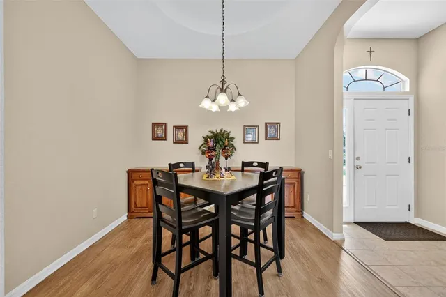 a dining room with furniture a chandelier and wooden floor