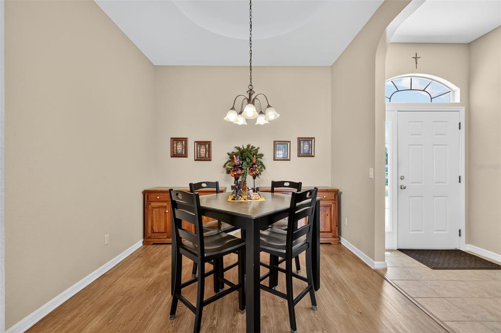 12103 Southeast 176th Loop Summerfield, FL 34491 - Photo 13 of 25 a dining room with furniture a chandelier and wooden floor