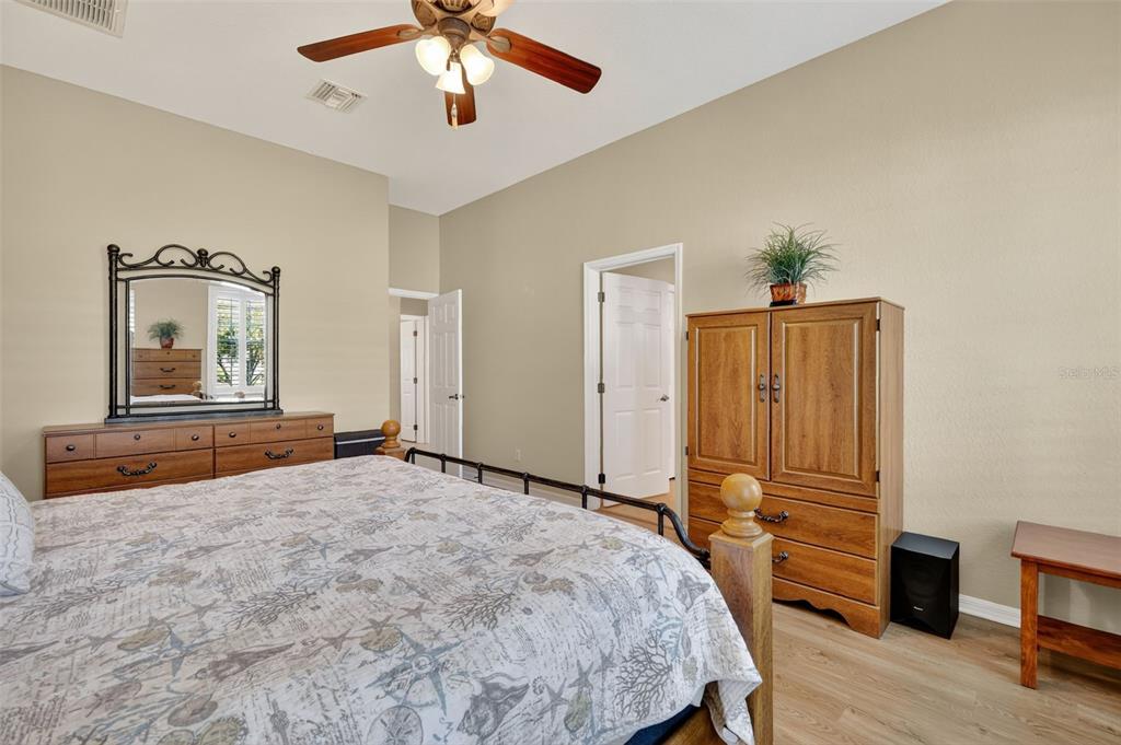 12103 Southeast 176th Loop Summerfield, FL 34491 - Photo 20 of 25 a bedroom with a bed and a chandelier