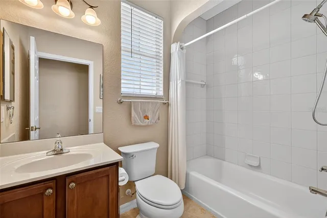 a bathroom with a toilet a sink a mirror a bathtub and shower