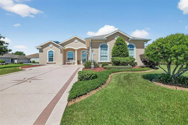 a view of a house with a big yard plants and large trees