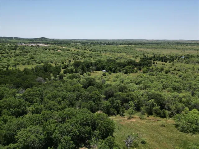 an aerial view of residential houses with outdoor space and trees