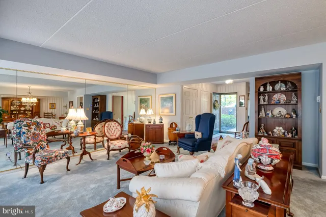 a living room with furniture kitchen view and a window