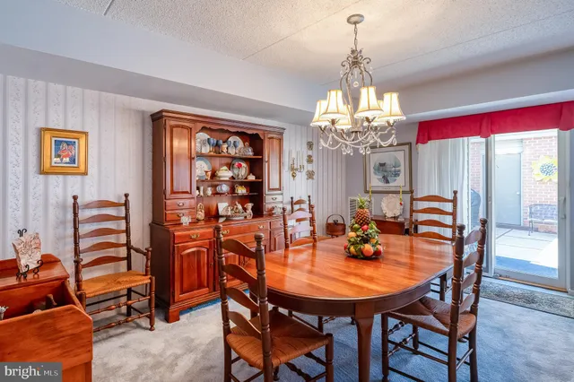 a dining room with furniture a chandelier and window