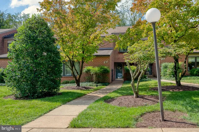 a front view of a house with garden and plants