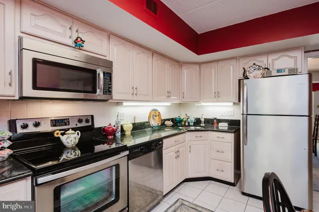 a kitchen with granite countertop a refrigerator stove and microwave