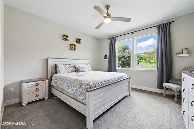 a bedroom with a bed and a large window