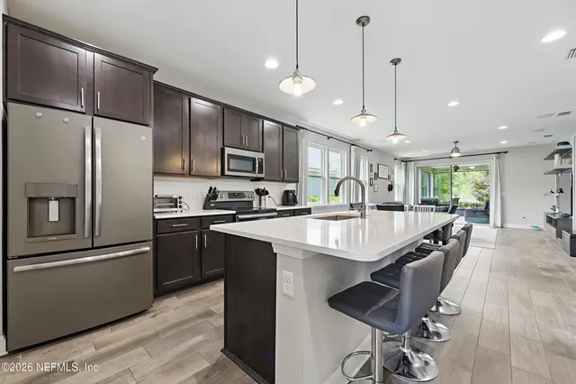 a kitchen with kitchen island a sink a counter and stainless steel appliances