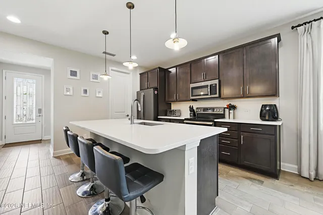 a kitchen with kitchen island a sink stove and microwave