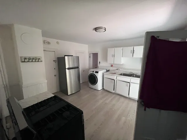 a kitchen with refrigerator and white cabinets