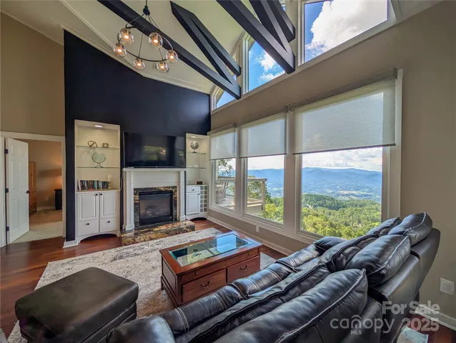 a living room with furniture a fireplace and a large window