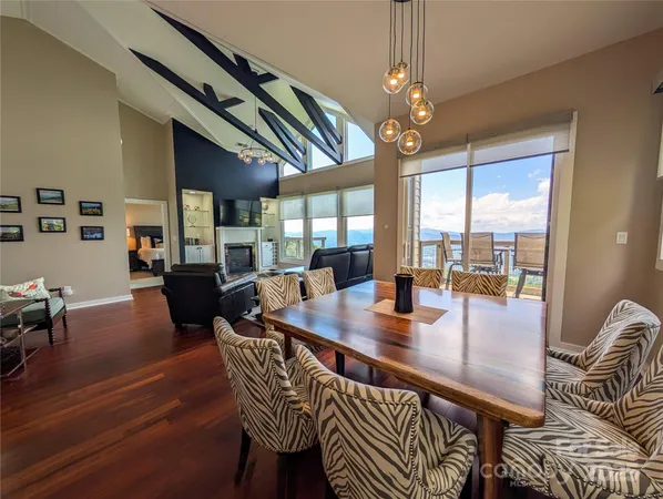 a dining room with wooden floor a chandelier a wooden table and chairs