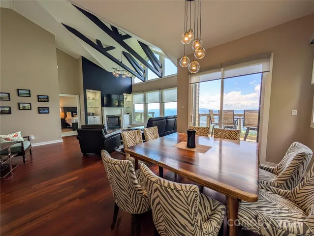 a dining room with wooden floor a chandelier a wooden table and chairs