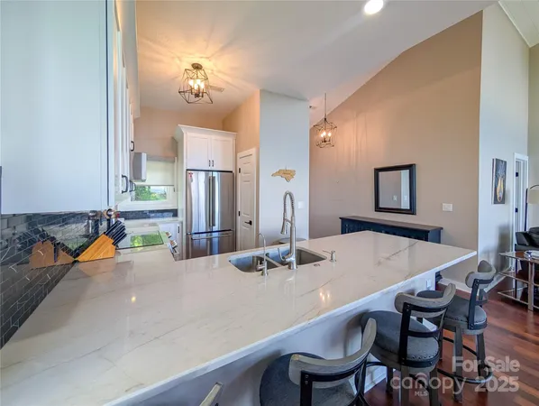 a kitchen with a dining table chairs and refrigerator