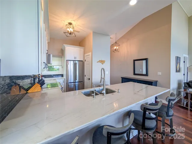 a kitchen with a dining table chairs and refrigerator
