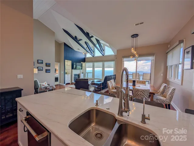 a kitchen with a stove a sink dishwasher a dining table and chairs with wooden floor