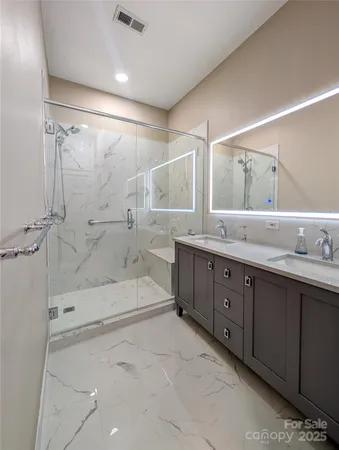 a spacious bathroom with a double vanity sink mirror double and shower