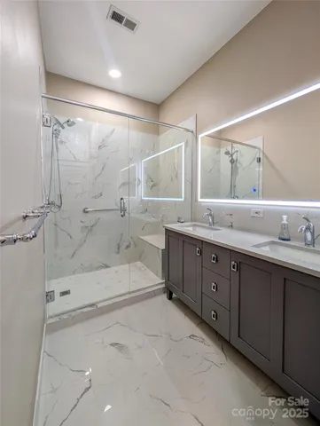 a spacious bathroom with a double vanity sink mirror double and shower