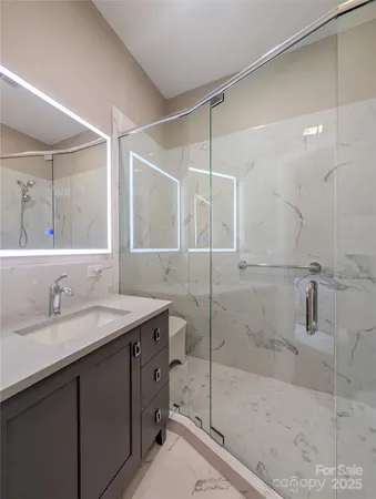 a bathroom with a granite countertop sink mirror and shower