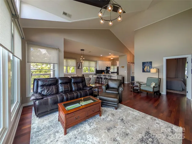 a living room with furniture a wooden floor and chandelier