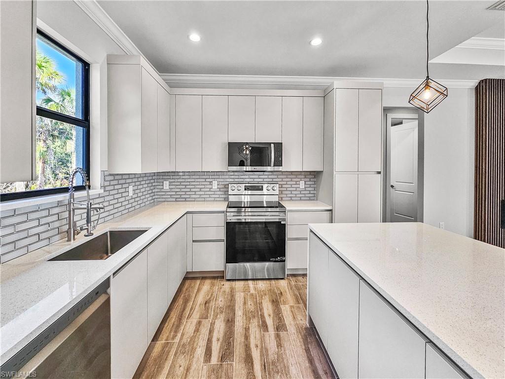 2997 28th Avenue Southeast Naples, FL 34117 - Photo 11 of 49 a kitchen with a sink stove and refrigerator