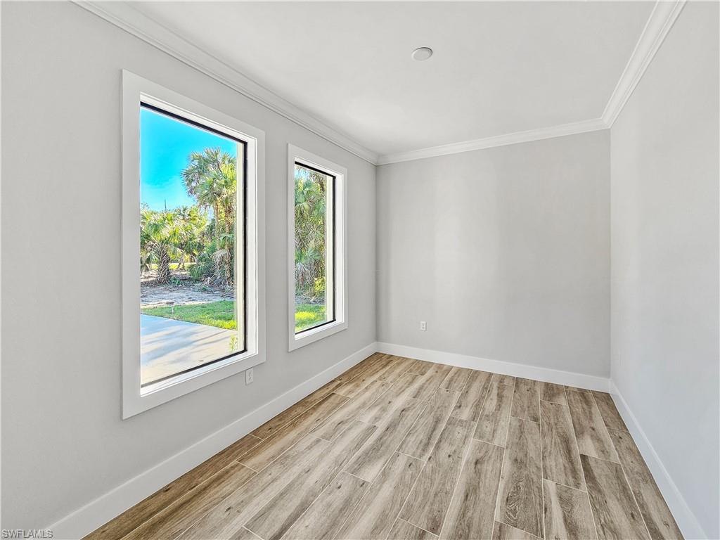 2997 28th Avenue Southeast Naples, FL 34117 - Photo 17 of 49 wooden floor in an empty room with a window