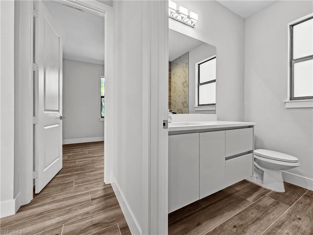 2997 28th Avenue Southeast Naples, FL 34117 - Photo 29 of 49 a bathroom with a toilet sink a mirror and window