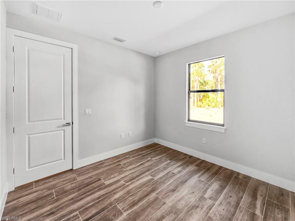 2997 28th Avenue Southeast Naples, FL 34117 - Photo 30 of 49 wooden floor in an empty room with a window