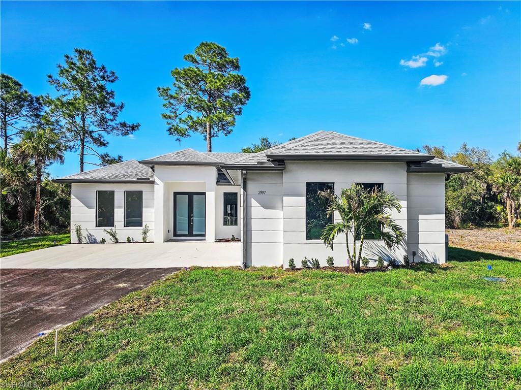 2997 28th Avenue Southeast Naples, FL 34117 - Photo 3 of 49 a front view of a house with garden