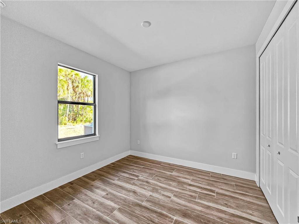 2997 28th Avenue Southeast Naples, FL 34117 - Photo 31 of 49 a view of empty room with wooden floor and fan