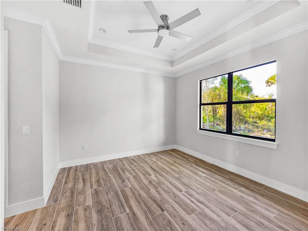 2997 28th Avenue Southeast Naples, FL 34117 - Photo 36 of 49 an empty room with a window and wooden floor