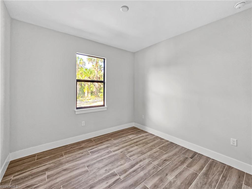 2997 28th Avenue Southeast Naples, FL 34117 - Photo 38 of 49 a view of an empty room with wooden floor and a window