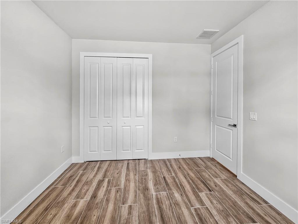 2997 28th Avenue Southeast Naples, FL 34117 - Photo 40 of 49 a view of a room with wooden floor and white walls