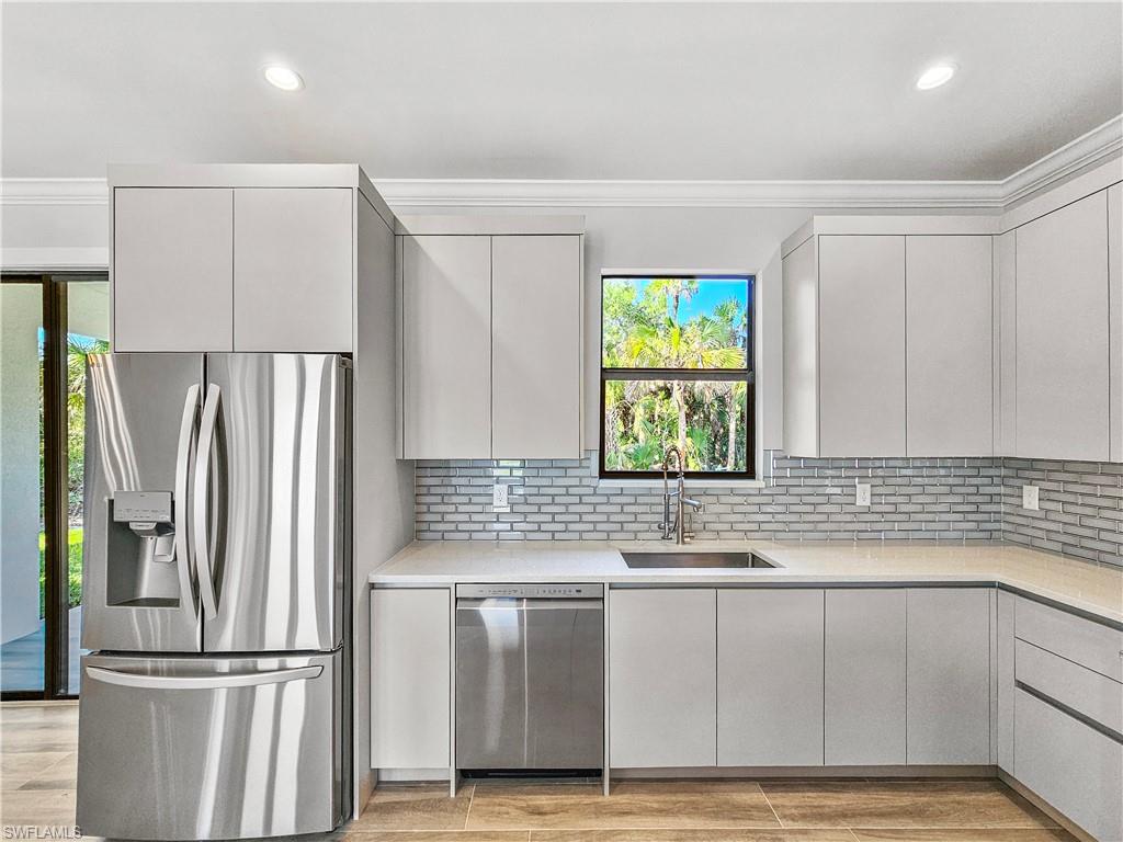 2997 28th Avenue Southeast Naples, FL 34117 - Photo 10 of 49 a kitchen with granite countertop a refrigerator and a sink