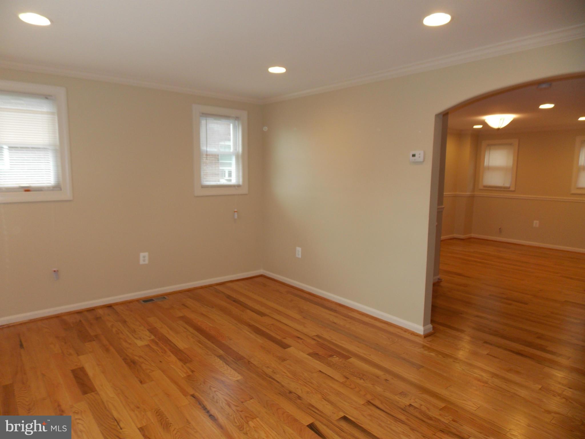 754 Charing Cross Road Baltimore, MD 21229 - Photo 3 of 15 an empty room with wooden floor and windows