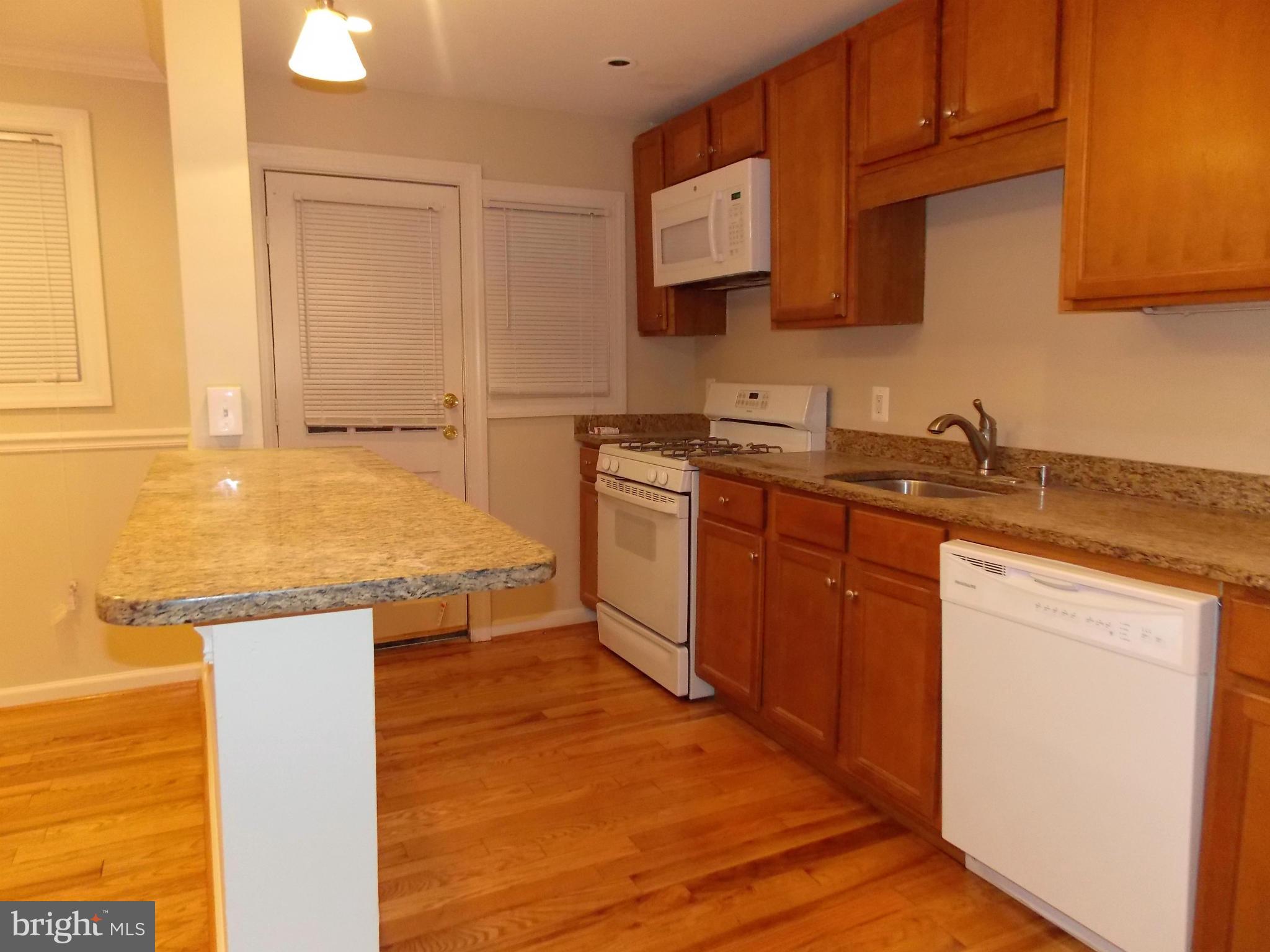 754 Charing Cross Road Baltimore, MD 21229 - Photo 6 of 15 a kitchen with stainless steel appliances granite countertop a sink stove and microwave