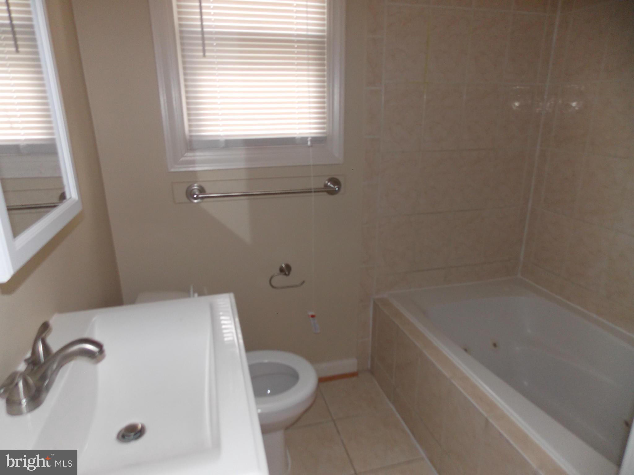 754 Charing Cross Road Baltimore, MD 21229 - Photo 8 of 15 a bathroom with a bathtub and a window