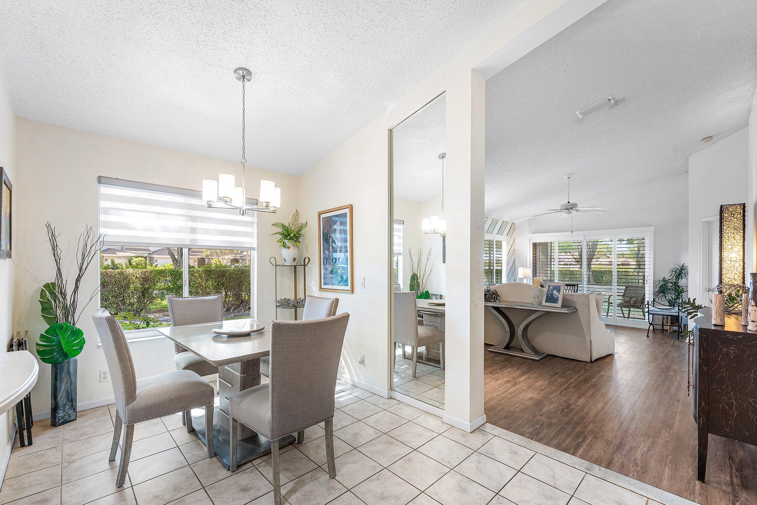 9112 Vineland Court, Unit A Boca Raton, FL 33496 - Photo 13 of 62 a view of a dining room with furniture wooden floor and chandelier