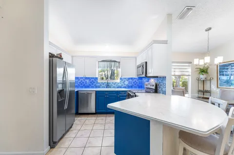 a large kitchen with granite countertop a sink and dishwasher a stove with wooden cabinets