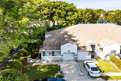 an aerial view of residential house with outdoor space and trees all around