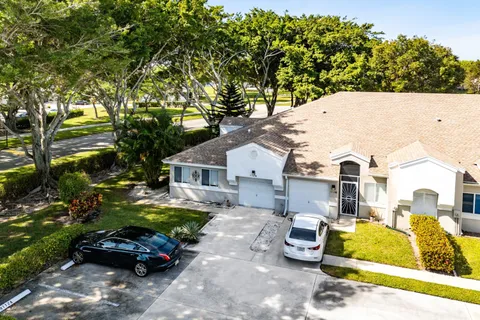 an aerial view of residential house with outdoor space and trees all around
