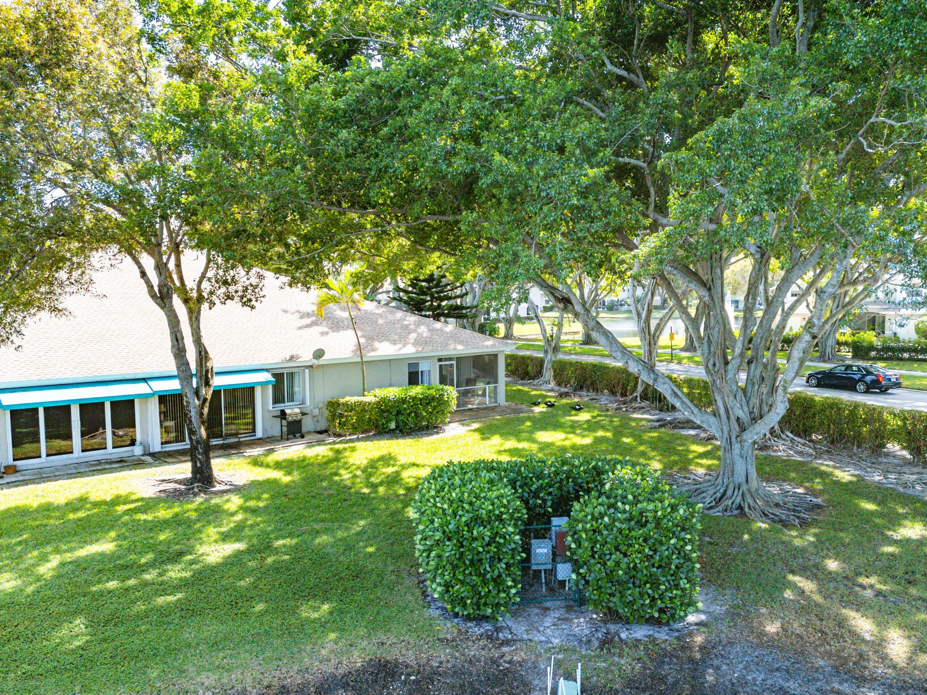 9112 Vineland Court, Unit A Boca Raton, FL 33496 - Photo 40 of 62 a view of a house with a big yard plants and large trees
