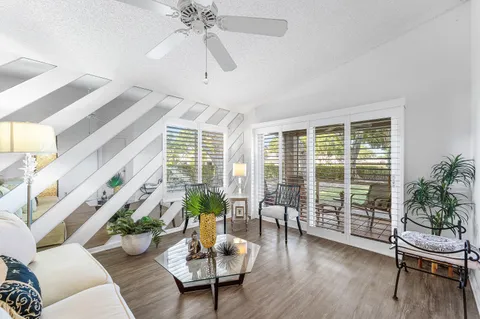a living room with a floor to ceiling window and wooden floor