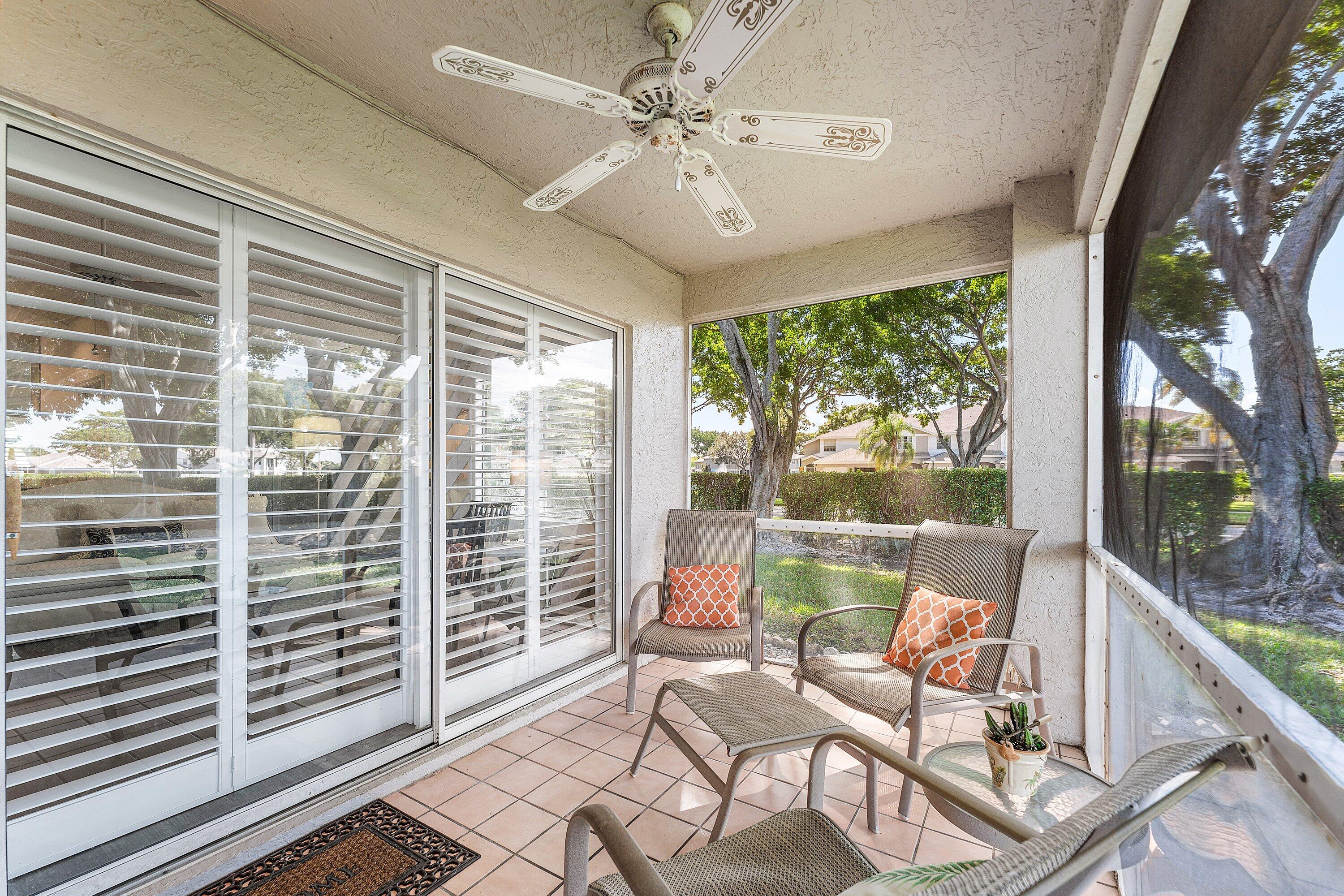 9112 Vineland Court, Unit A Boca Raton, FL 33496 - Photo 10 of 62 a living room with a floor to ceiling window and wooden floor